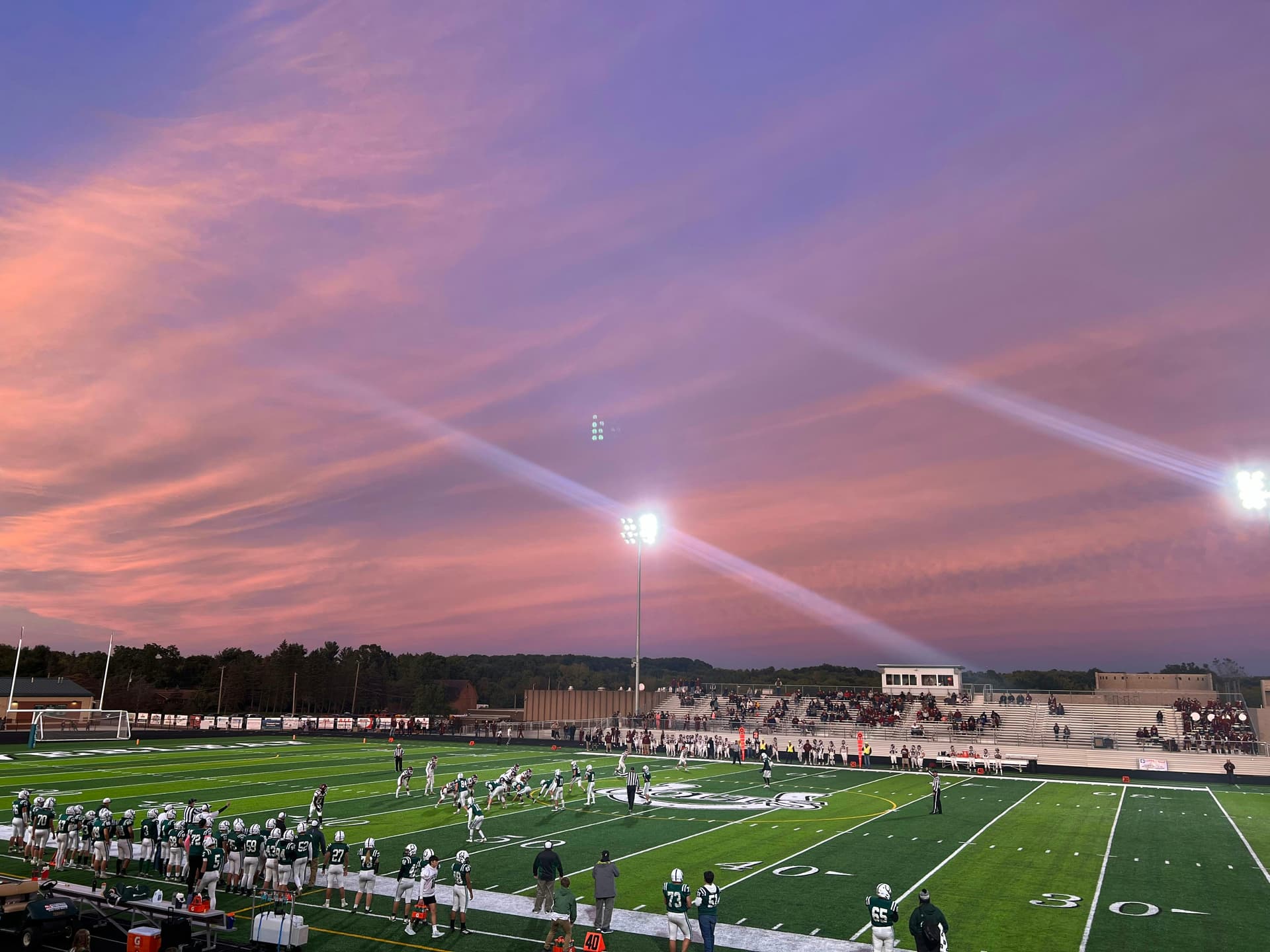Partita di football in uno stadio scolastico al tramonto, simbolo dello sport, della comunità e delle tradizioni del sistema scolastico americano.