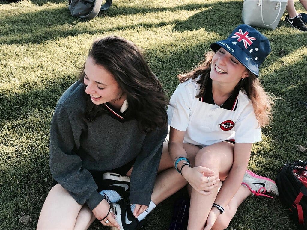 Students sitting on the grass during a school break as part of a school programme in Australia.