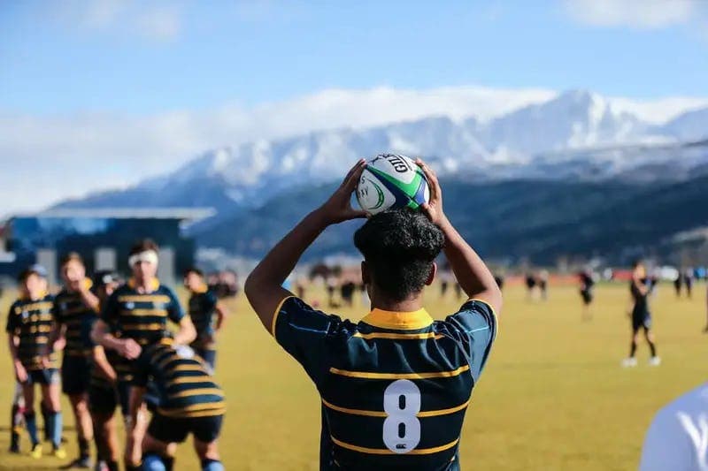 Student playing rugby during a school exchange year in New Zealand, taking part in organised school sports activities.