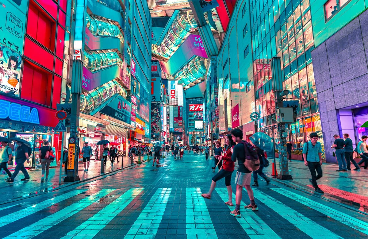 A busy Tokyo street illuminated by neon signs, showcasing Japan’s vibrant urban culture during a school exchange year.