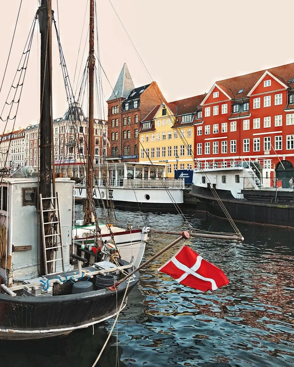 Danish canal with boats and national flag during a school exchange programme in Denmark, showcasing local culture and daily life.