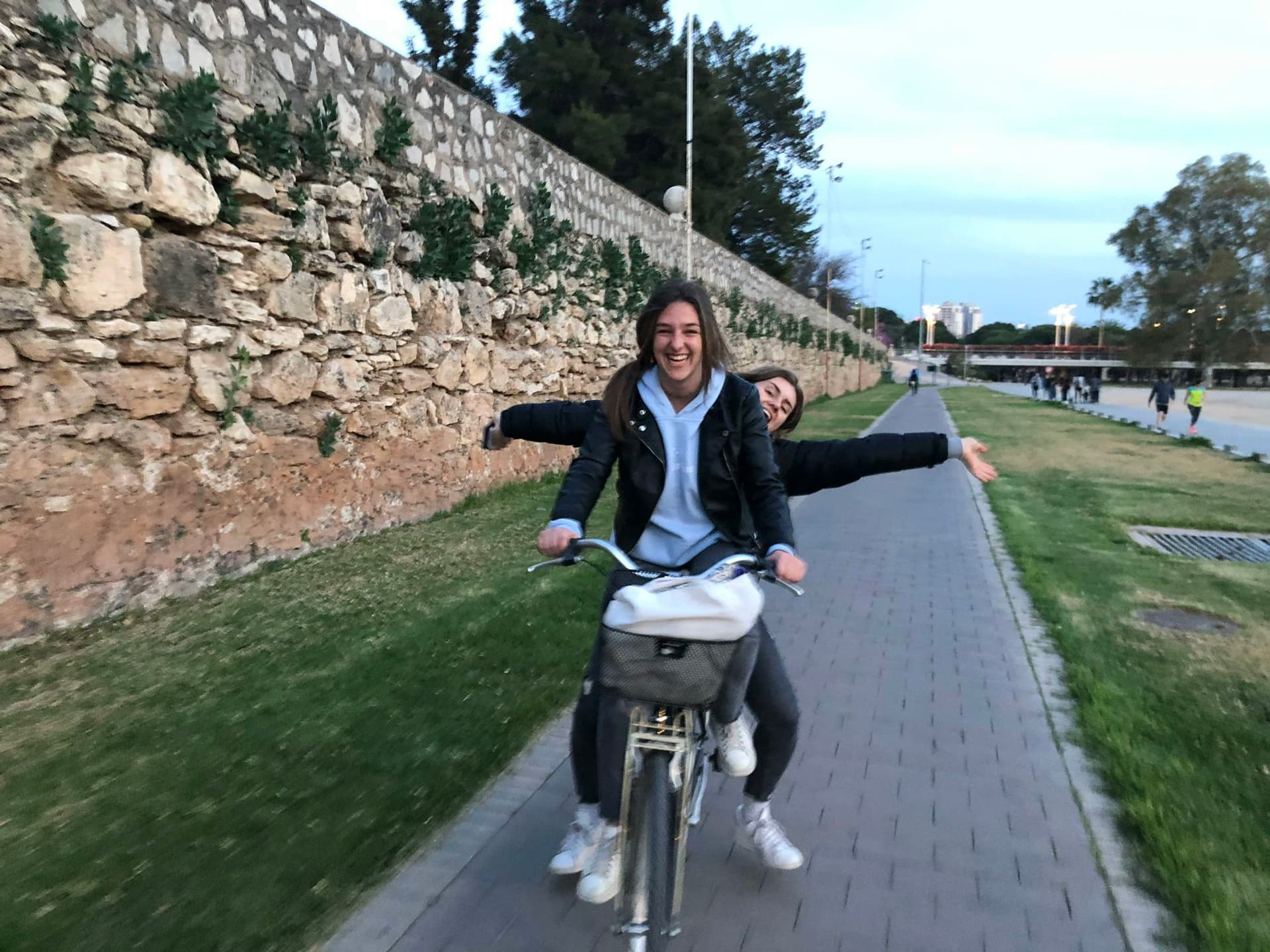 Image of two girls having fun cycling in Seville, an unforgettable experience during a study programme in Spain, filled with laughter and stunning landscapes.