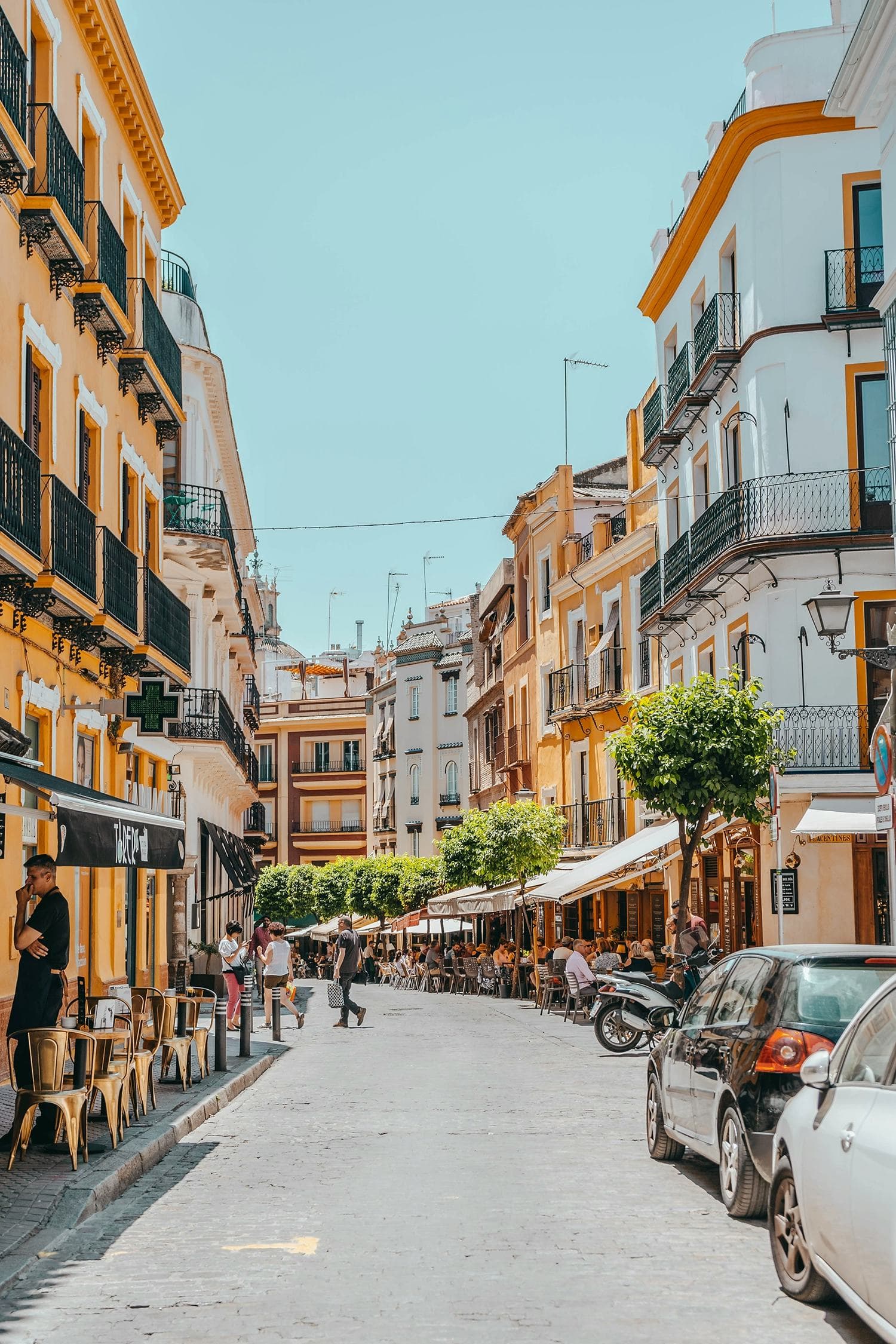 Image of a typical street in Seville, with outdoor cafes and vibrant colours, perfect for an unforgettable experience during a study programme in Spain.