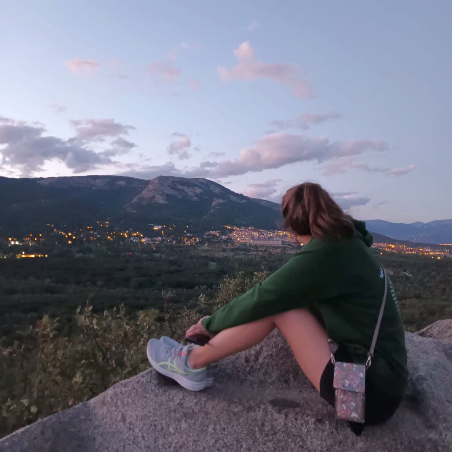 Image of a student contemplating the mountainous landscape and illuminated city, a unique experience during a study programme in Spain.