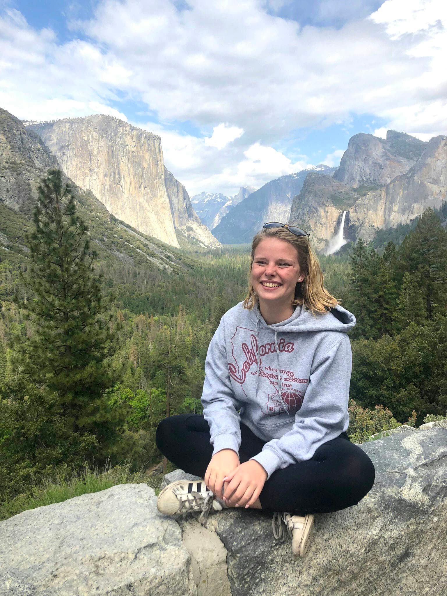 Studentessa seduta nella natura durante un anno nel sistema scolastico americano, tra paesaggi iconici, scoperta del territorio e crescita personale negli Stati Uniti.