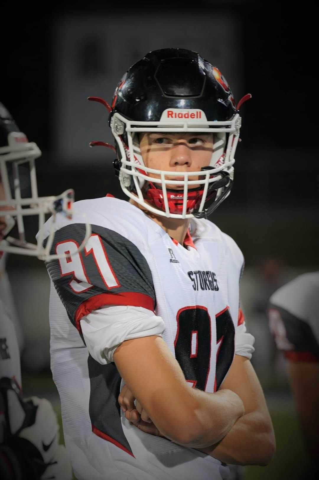 Studente indossa la divisa da football durante una partita scolastica, vivendo sport, disciplina e spirito di squadra del sistema scolastico americano.