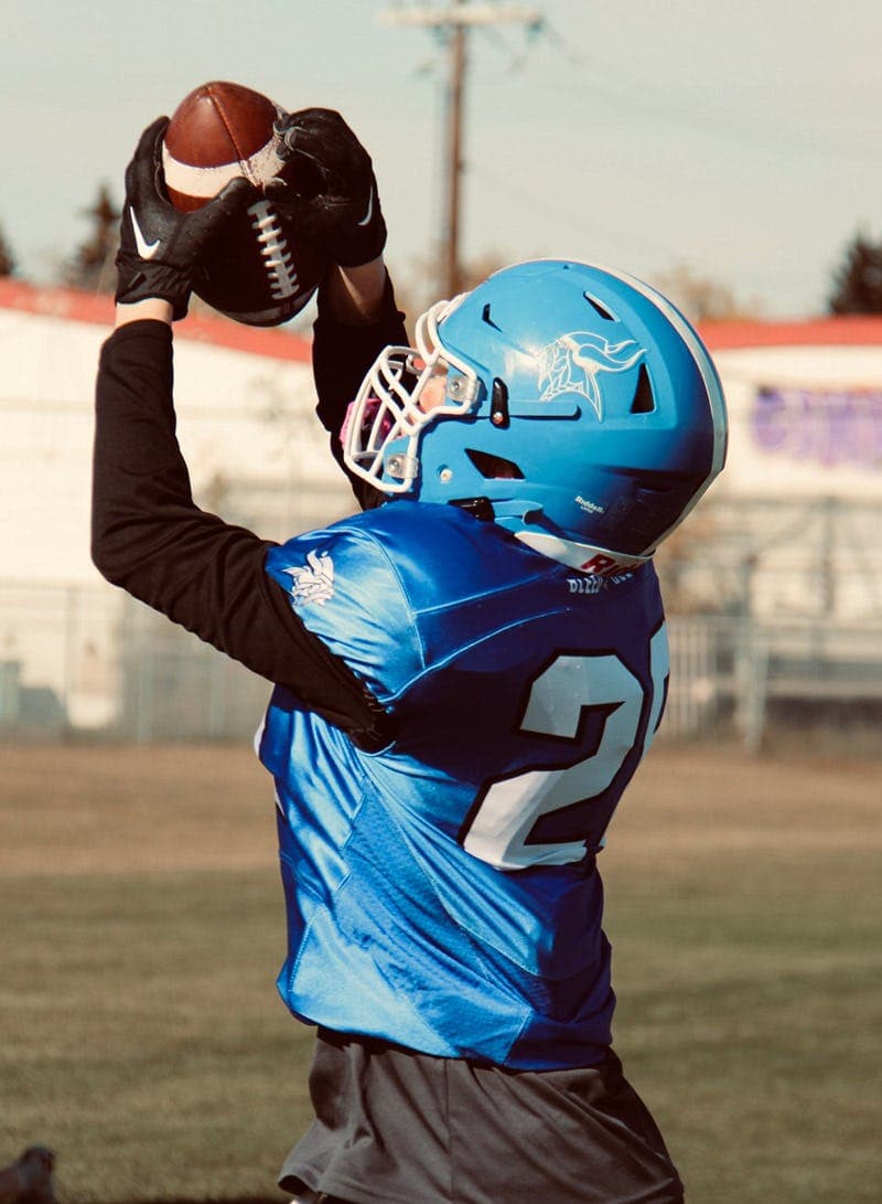 Student playing American football at school during a school year in Canada as part of the Canadian school programme.