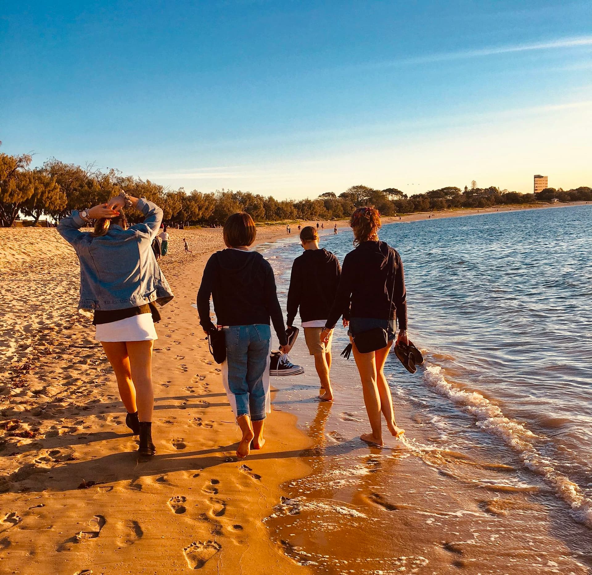 Students walking on the beach during school life abroad in Australia, enjoying leisure time alongside lessons.