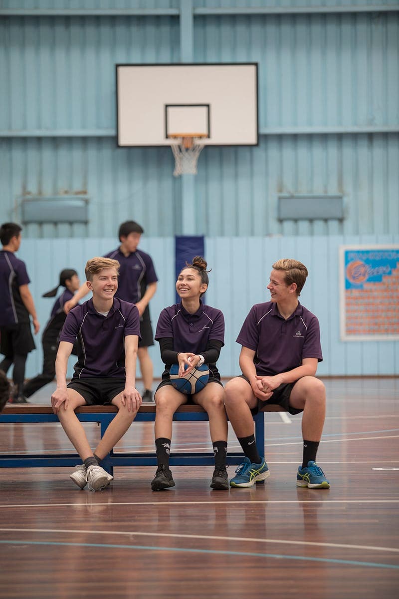 Students sitting in a school gym during a school programme in Australia, part of everyday school life.