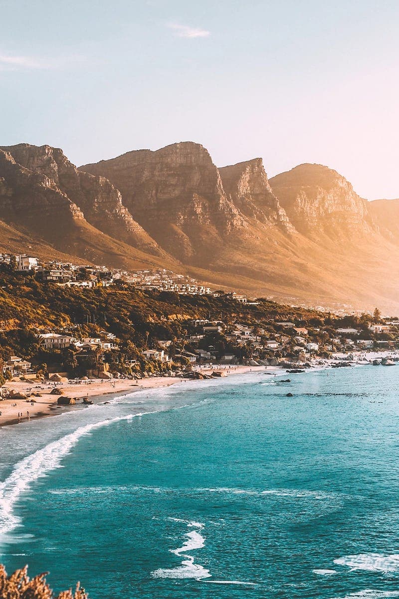 A panoramic view of Cape Town’s coastline, with mountains towering above the ocean, experiencing a once-in-a-lifetime adventure during the school exchange programme in South Africa.