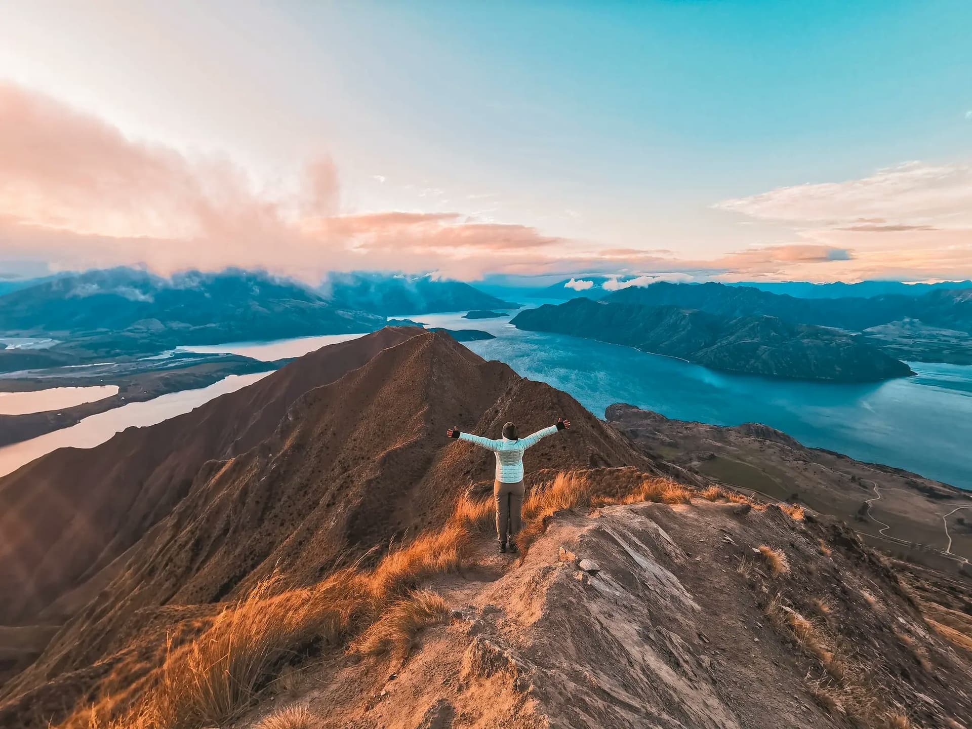 Student on a mountain ridge with lake views, representing a school year in New Zealand focused on nature and personal growth