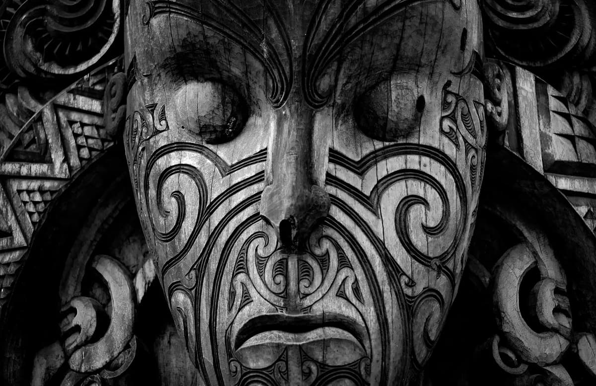 Close-up of a traditional Māori carving in New Zealand, showing engraved patterns linked to cultural identity and spiritual heritage.