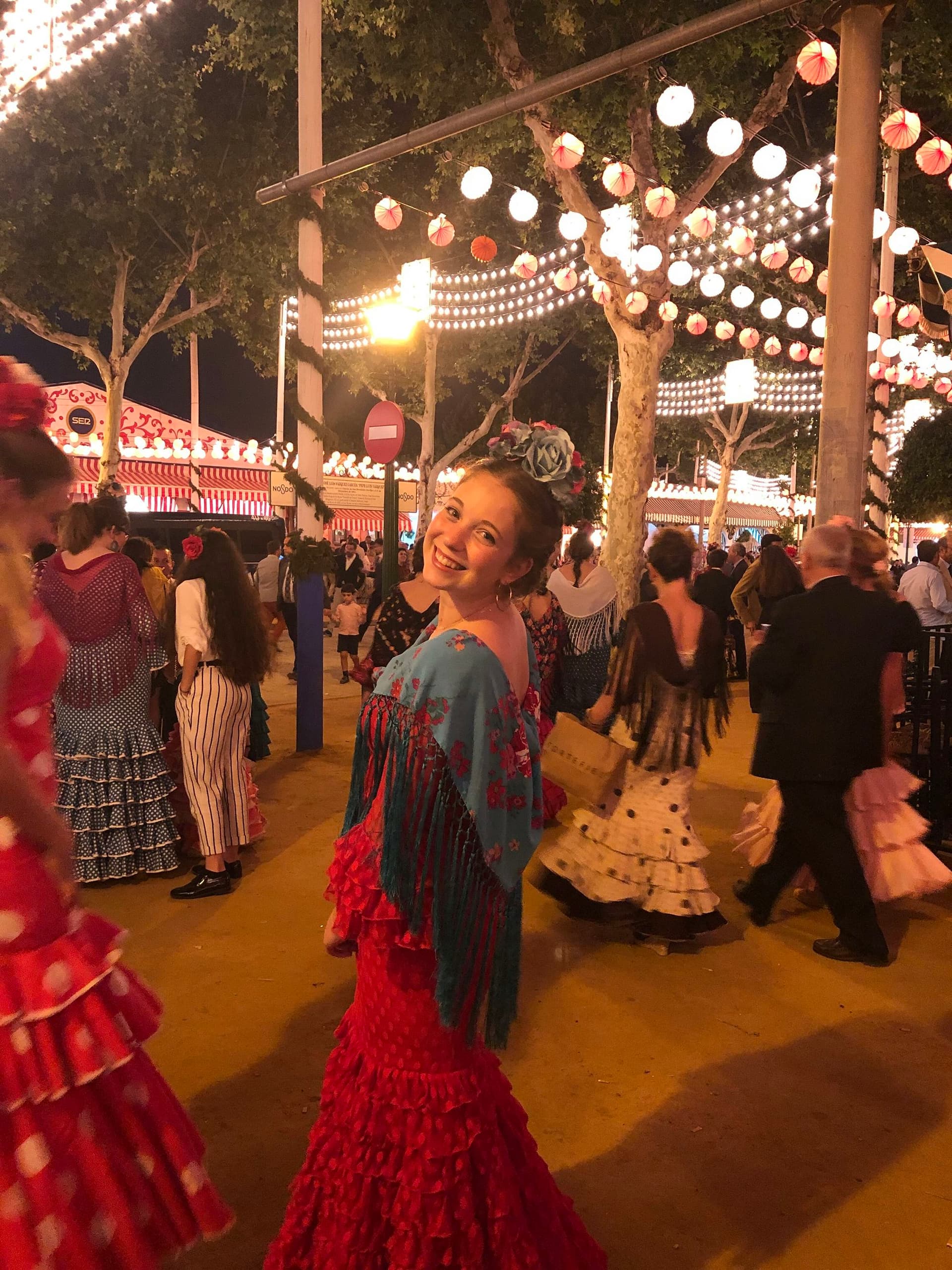 Image of a student participating in the traditional Feria de Abril festival in Seville, Spain, surrounded by traditional costumes and festive lights. Perfect for a study programme in Spain.