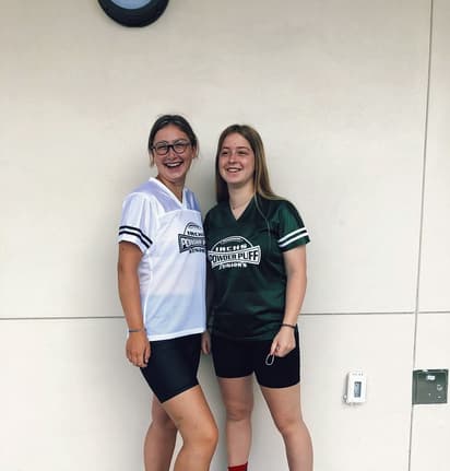 Two high school students smiling together in school shirts, showing friendship and social life during a school exchange programme in the USA.