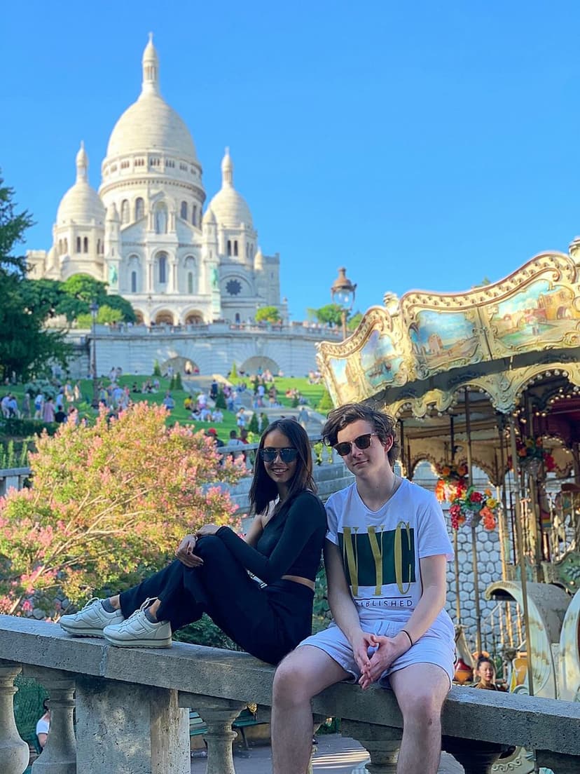 Two students smiling in front of the Sacré-Cœur in Paris, an unforgettable cultural experience during their study year abroad in France.